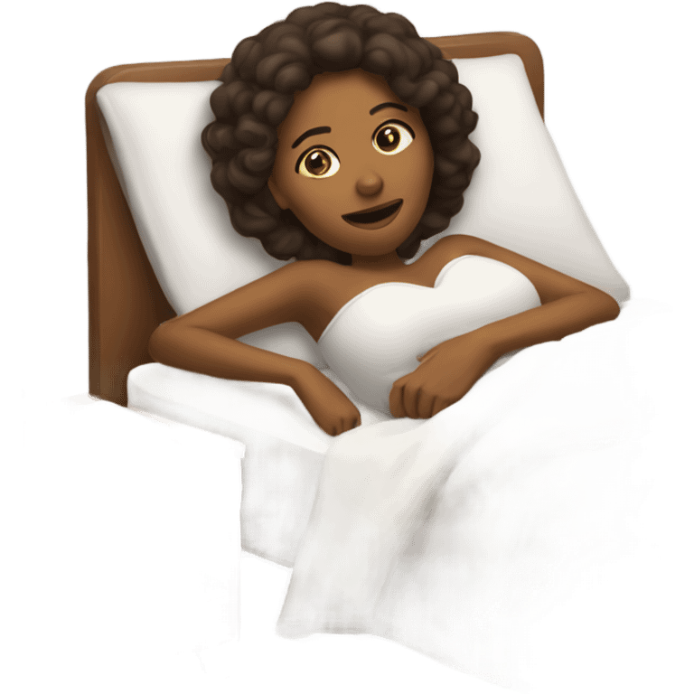 Brown woman laying in bed holding a phone emoji