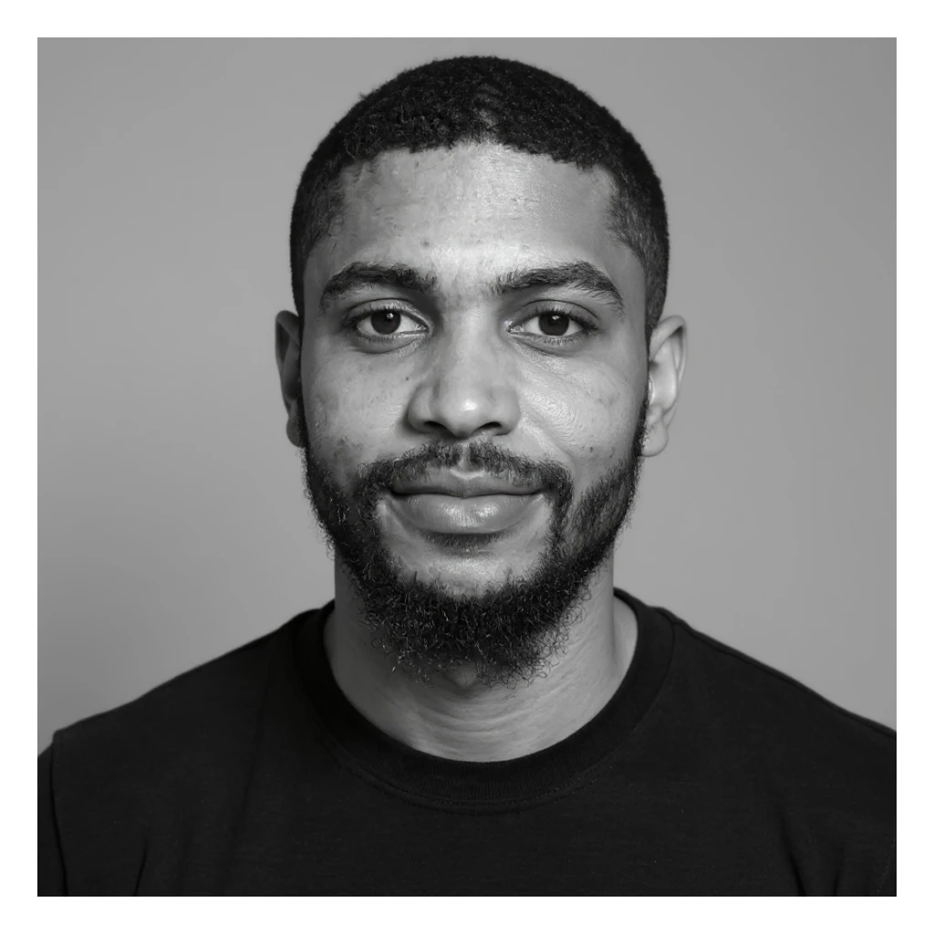 A professional portrait in monochrome. Plain black crew neck shirt. Tailored to LinkedIn. Tech boy vibe (programmer) sticker