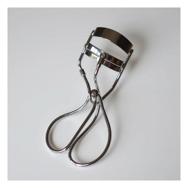 silver eyelash curler, close-up view, detailed, chrome finish sticker