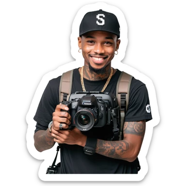 Young African cinematographer with tattoo-covered arms, wearing all black clothing and a baseball cap, holding a DSLR camera. Has dark brown eyes, a bright smile, and a small goatee. sticker