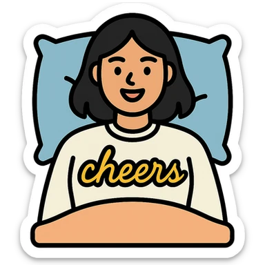 A woman with shoulder-length black hair, light to medium skin tone, full cheeks, and almond-shaped eyes, wearing a white sweater with the word 'cheers' in gold script, lying comfortably on a bed with soft lighting, joyful and radiant expression sticker