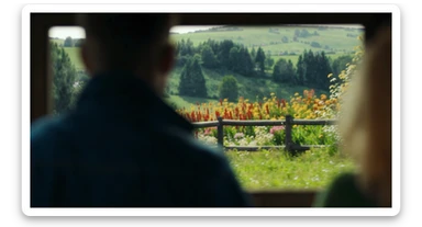 "Two shot" of a person in the foreground, blurred plants in the foreground (frame within a frame), a wooden fence and colorfull flowers in the midground, Poland, rolling hills in the background, cinematic depth of field, layered composition, natural lighting sticker