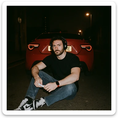 Grunge-style analog photo, London 2025, person inspired by the reference image sitting on the ground, Nissan GT 86 behind, model pose, black t-shirt, jeans, Nike Air Jordan low, using flash, urban night, analog grain, 7/8. sticker