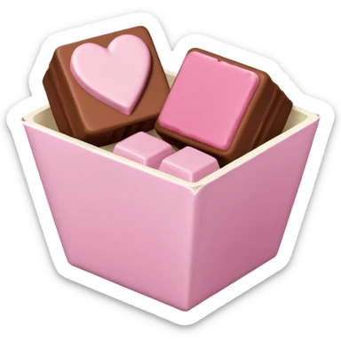 Two square milk chocolate pralines, Each praline is a sharp-edged cube with smooth glossy chocolate coating, placed in a small white fluted paper candy cup. On top of each cube is a flat pastel pink heart-shaped icing sticker