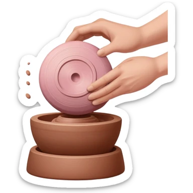 one hand throwing a pink ball of clay onto a completely empty pottery wheel with no pottery or other clay on it sticker