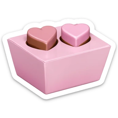 Two square milk chocolate , Each praline is a sharp-edged cube with smooth glossy chocolate coating, placed in a small white fluted paper candy cup. On top of each cube is a flat pastel pink heart-shaped icing sticker