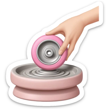 one hand throwing a pink ball of clay onto a flat silver pottery wheel surface sticker