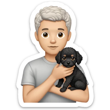 Man with short salt and pepper hair holding a black cavapoo puppy with a white chest sticker