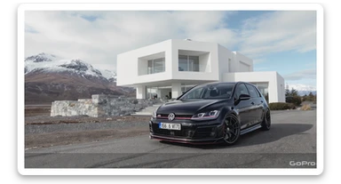 black Golf A4 with bodykit, in background is modern huge two flors white villa, in distance are iceland mountains, rule of thirds, shot on gopro hero, noise camera sticker