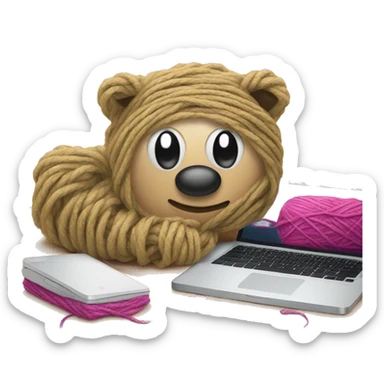 Laptop on a bed with a ball of yarn sticker