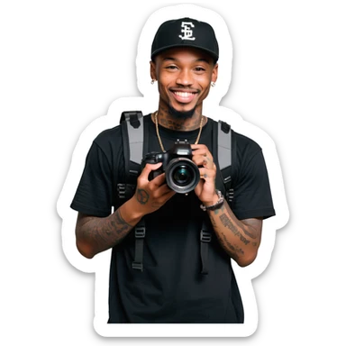 Young African cinematographer with tattoo-covered arms, wearing all black clothing and a baseball cap, holding a DSLR camera. Has dark brown eyes, a bright smile, and a small goatee. sticker
