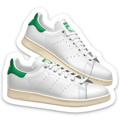 A pair of white Adidas Stan Smith sneakers arranged with one shoe behind the other, white leather with green heel tabs, classic design, both shoes visible sticker
