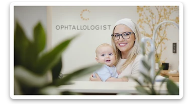 Cinematic still, blurred plants in the foreground (close to the camera), Proffesional advertising of a smiling european white woman with glasses smiling holding baby, minimalistic ophthalmologist interior in background, leading  lines, "rule of thirds", 60/30/10 colors, soft light, warm colors sticker