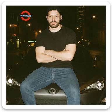 Grunge-style analog photo, London 2025, person inspired by the new reference image sitting on the hood of a Nissan GT 86, model pose, black t-shirt, jeans, Nike Air Jordan low, using flash, city lights, analog grain, 2/8. sticker