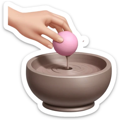 one hand throwing a pink ball of clay onto a flat silver pottery wheel surface sticker