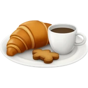 A croissant in a plate with a side of brown gingerbread cookies and some coffe sticker