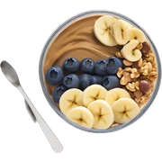 Açai bowl in a clear cup with layers of peanut butter, cashew nuts, granola, condensed milk and banana sliced and blueberrys on top sticker