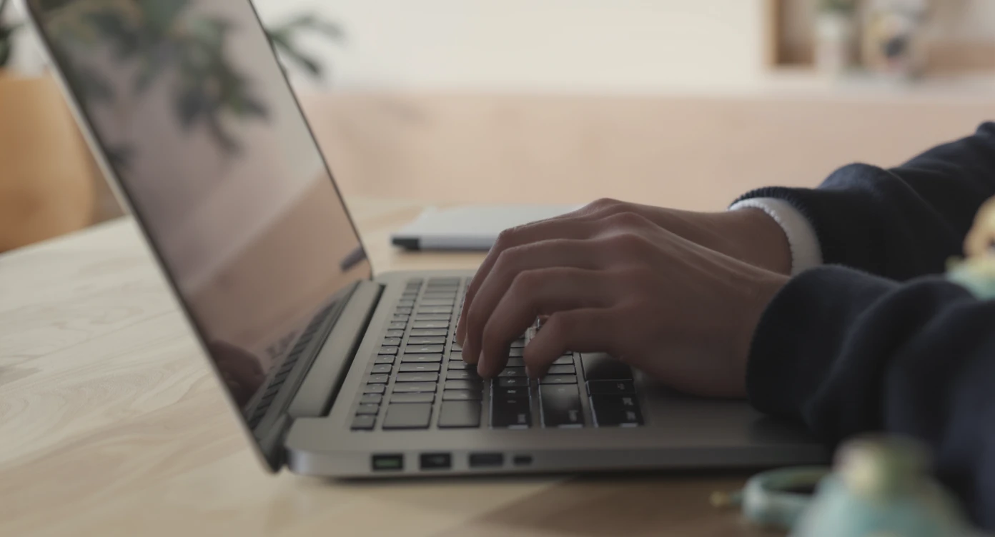 POV shot, Man writing on macbook pro keyboard, minimalistic environment emoji