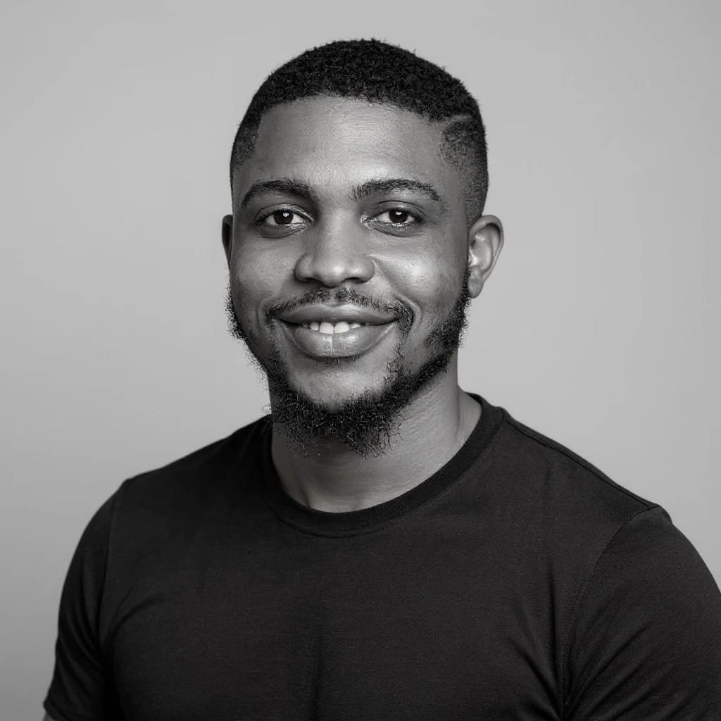 A professional portrait of me in monochrome. Plain black crew neck shirt. Tailored to LinkedIn. Tech boy vibe (programmer). I’m a black man from Nigeria. Retain facial features from attached image. Make face smoothie and healthy. No accessories. Light gray background to make subject more visible. emoji