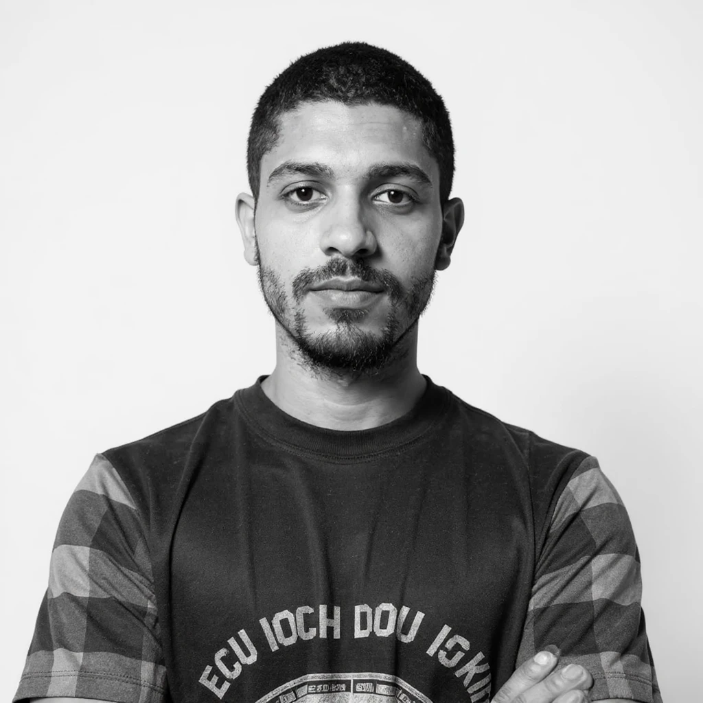 Create a corporate portrait in monochrome style of a person wearing a tech boy (programmer) crew neck shirt. The look should be professional and clean with a neutral background, emphasizing a monochrome black and white DSLR photography style. emoji