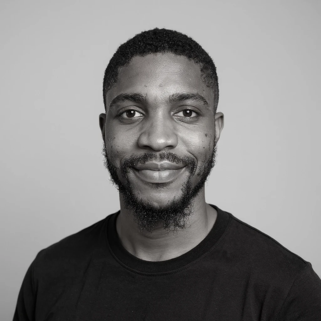 A professional portrait of me in monochrome. Plain black crew neck shirt. Tailored to LinkedIn. Tech boy vibe (programmer). I’m a black man from Nigeria. Retain facial features from attached image. Make face smoothie and healthy. No accessories. Light gray background to make subject more visible. emoji