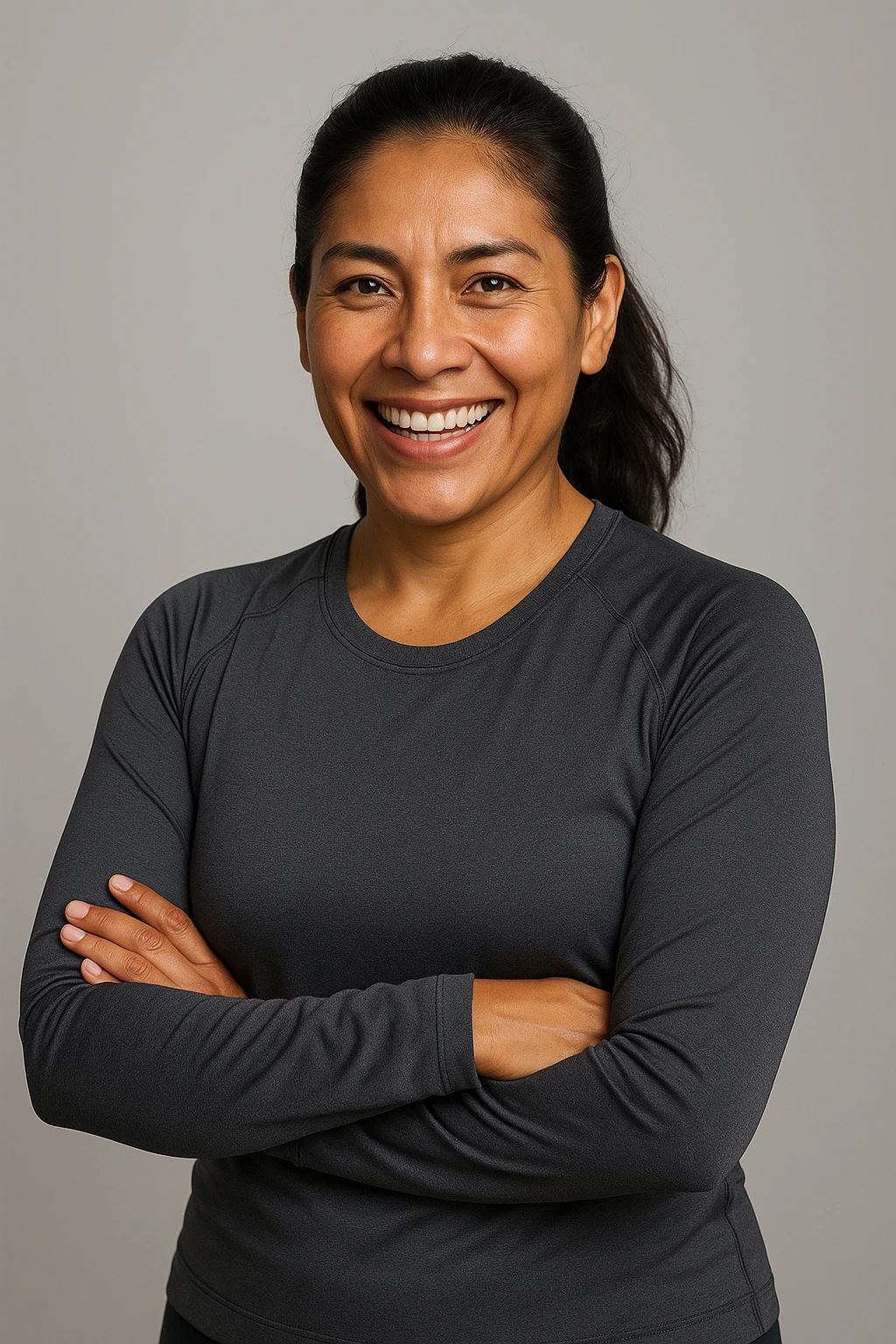 Portrait of a 40-year-old Peruvian woman, wheat-colored skin, dark hair, active and healthy attitude, lead-colored sportswear, friendly and energetic face, ideal for a supplement brand aimed at Peruvian adults. emoji