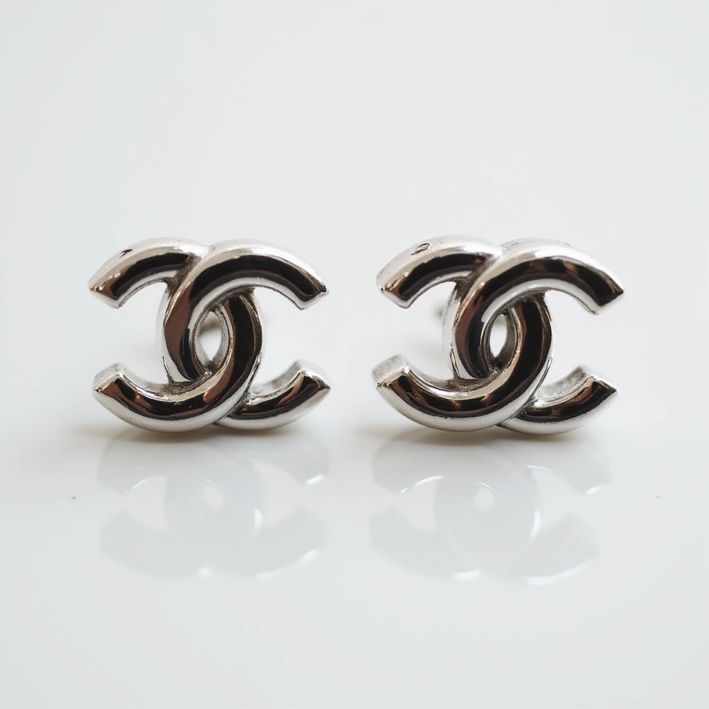 photorealistic pair of silver Chanel logo stud earrings, elegant emoji