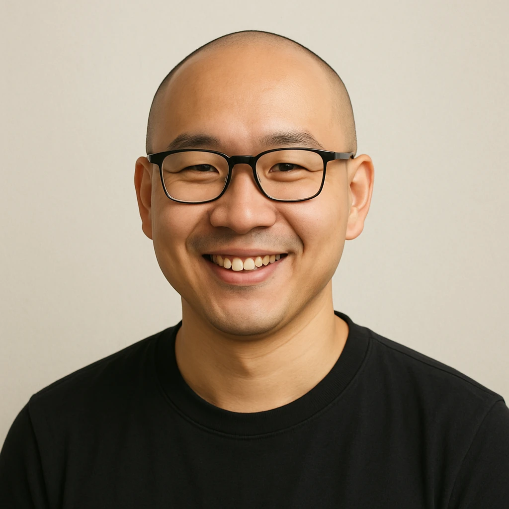 skinhead Asian man with glasses, smiling, minimal background emoji