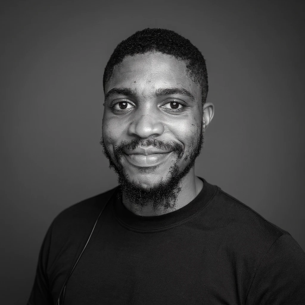 A professional portrait of me in monochrome. Plain black crew neck shirt. Tailored to LinkedIn. Tech boy vibe (programmer). I’m a black man from Nigeria. Retain facial features from attached image. Smooth skin. No accessories. emoji