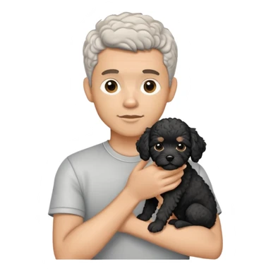 Man with short salt and pepper hair holding a black cavapoo puppy with a white chest sticker